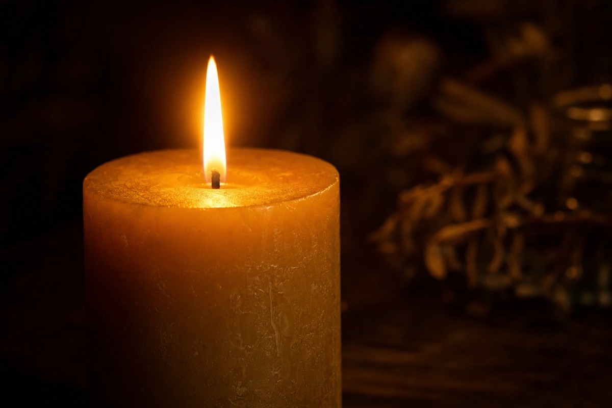 Detail van de gelijkmatige vlam van een brandende handgemaakte kaars